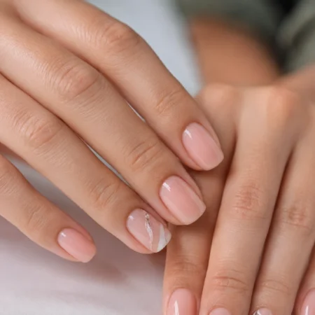 Builder gel nails with natural nude overlay showing strong, glossy, short to medium‑length nails.