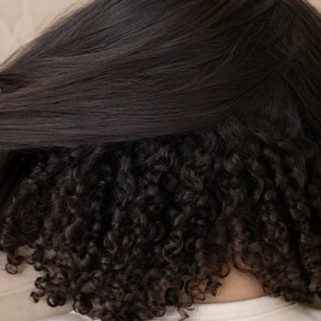 Woman's hair showing irish curls pattern with straight canopy on top and curly layers underneath