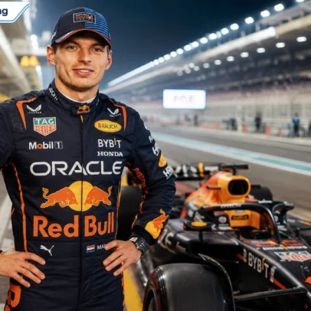 Max Verstappen in Oracle Red Bull Racing suit standing beside his F1 car in the pit lane