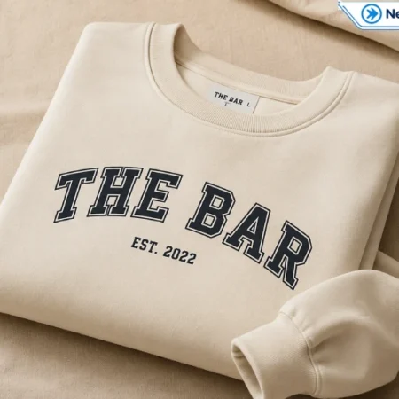 Oversized cream sweatshirt with bold varsity-style lettering, styled in a minimalist streetwear look